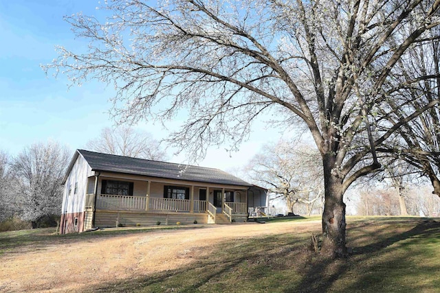 view of front of property featuring a front yard, covered porch, and driveway