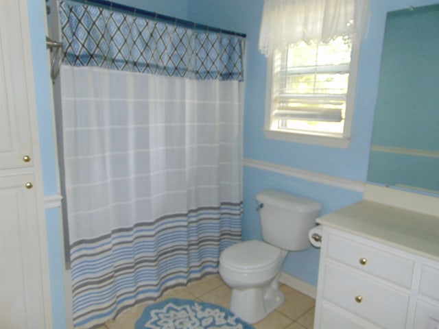 bathroom featuring toilet, a shower with curtain, vanity, and tile patterned floors