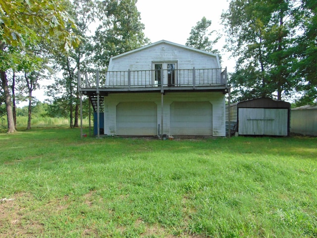 rear view of house featuring a yard, a garage, a storage shed, and a wooden deck