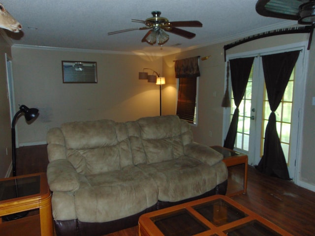 living room featuring hardwood / wood-style floors, ceiling fan, and crown molding