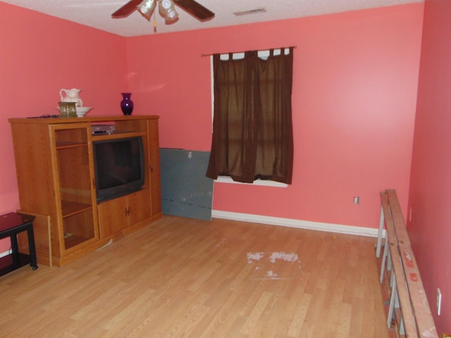 living room featuring light hardwood / wood-style flooring and ceiling fan