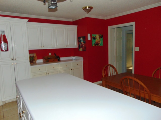 kitchen featuring light tile patterned floors, white cabinetry, and ornamental molding