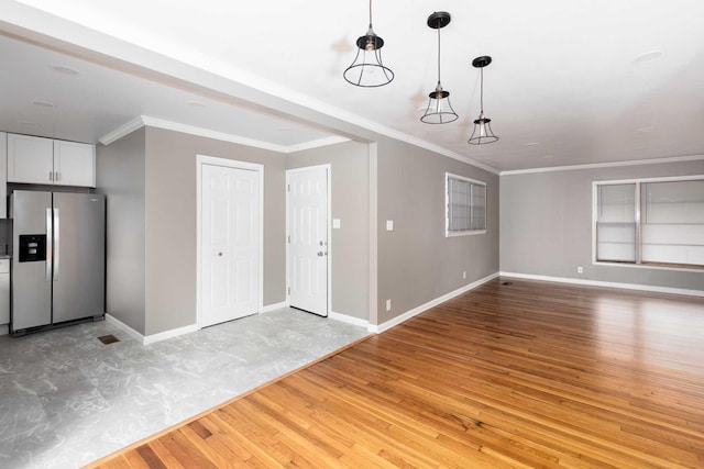 entrance foyer with crown molding, light wood-style flooring, and baseboards