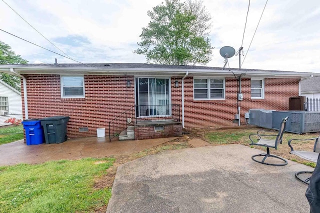 back of property with a patio, crawl space, and brick siding