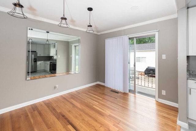 unfurnished dining area with visible vents, crown molding, light wood-style flooring, and baseboards