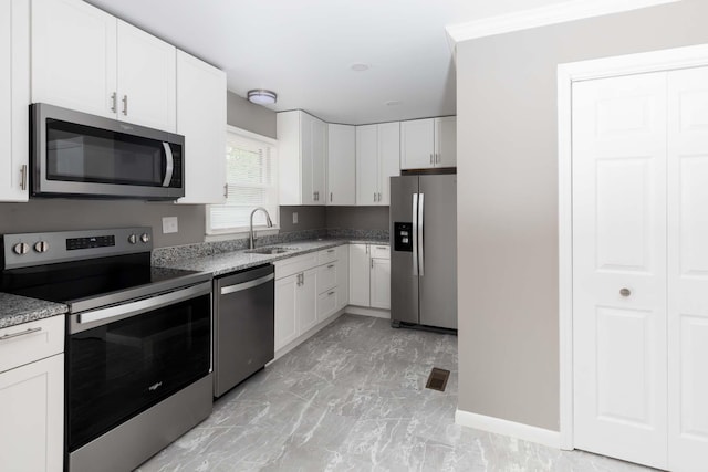kitchen featuring appliances with stainless steel finishes, marble finish floor, white cabinets, a sink, and visible vents