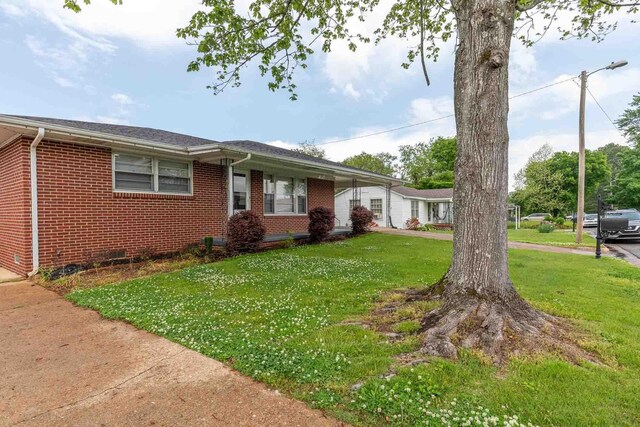 ranch-style house with brick siding and a front yard