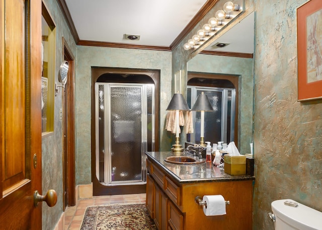 bathroom with vanity, toilet, a shower with door, and crown molding