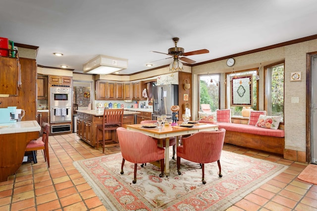 dining space with light tile patterned floors, ceiling fan, and ornamental molding