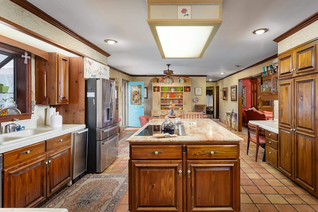 kitchen featuring sink, a kitchen island, ornamental molding, and appliances with stainless steel finishes