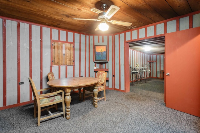 carpeted dining space with ceiling fan and wood ceiling