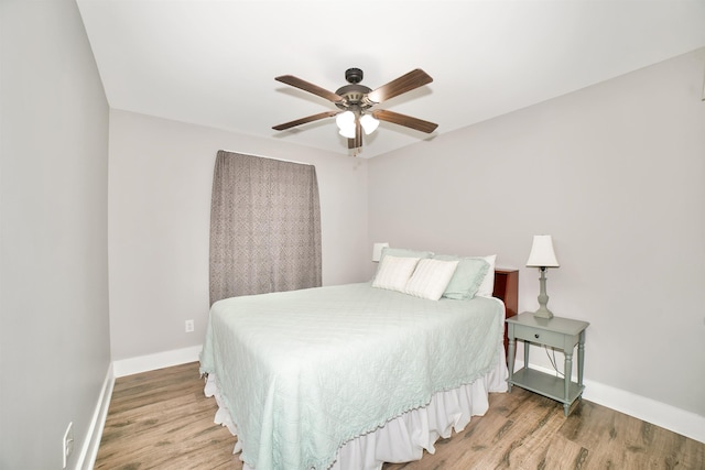  - bedroom with baseboards, ceiling fan, and wood finished floors