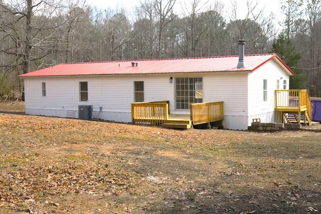 rear view of property featuring a deck and central AC unit