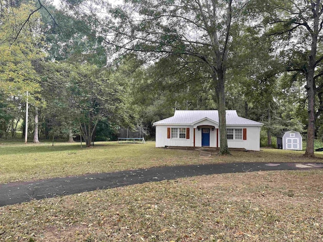 view of front facade with a front yard, a trampoline, a storage unit, and covered porch