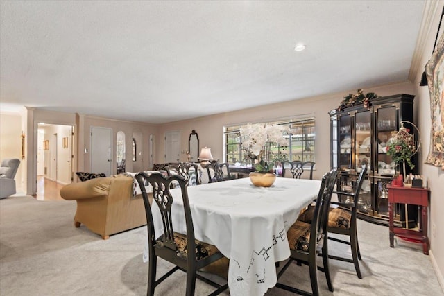 dining room with light carpet and ornamental molding