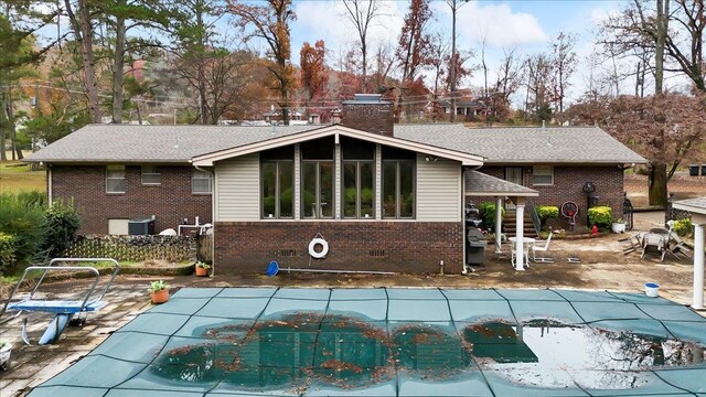 back of house with cooling unit, a patio, and a covered pool