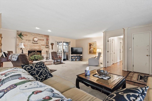 carpeted living room featuring a stone fireplace, crown molding, and a textured ceiling