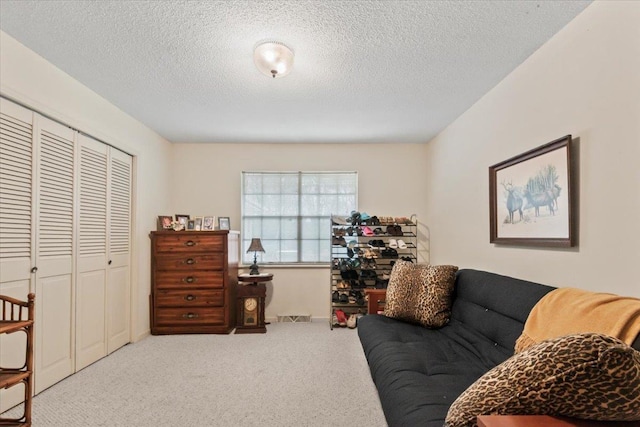 interior space featuring a textured ceiling and light colored carpet