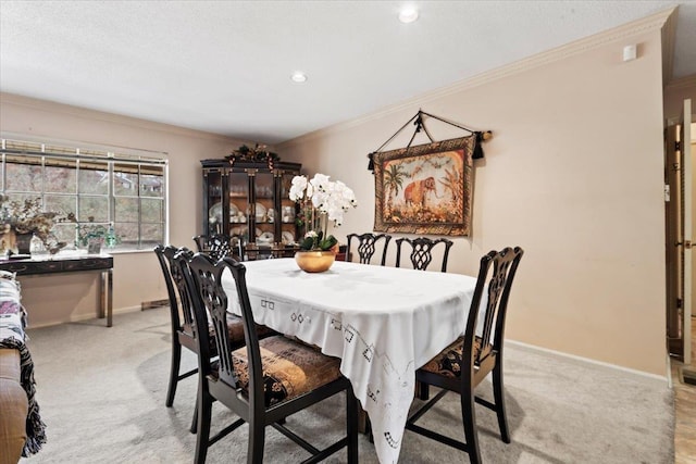 carpeted dining space with ornamental molding