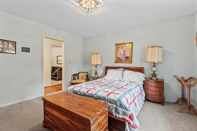 bedroom with a textured ceiling and light carpet