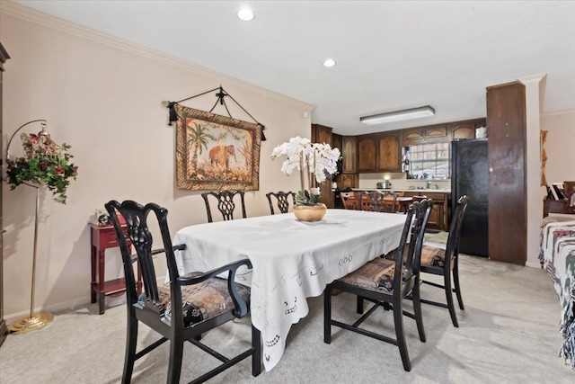 carpeted dining area featuring ornamental molding