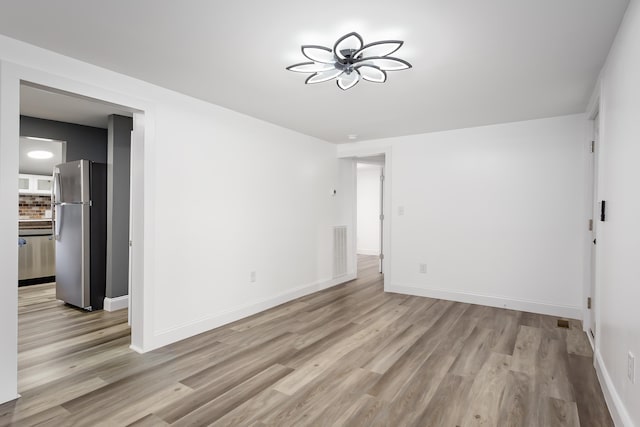  - spare room with light wood finished floors and baseboards
