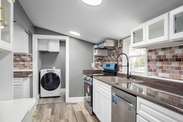  - kitchen with washer / clothes dryer, appliances with stainless steel finishes, a sink, tasteful backsplash, and vaulted ceiling