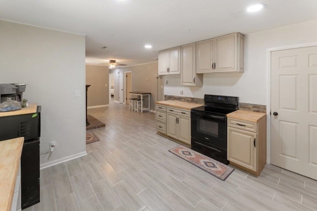 kitchen with black / electric stove, ceiling fan, cream cabinets, and wood counters