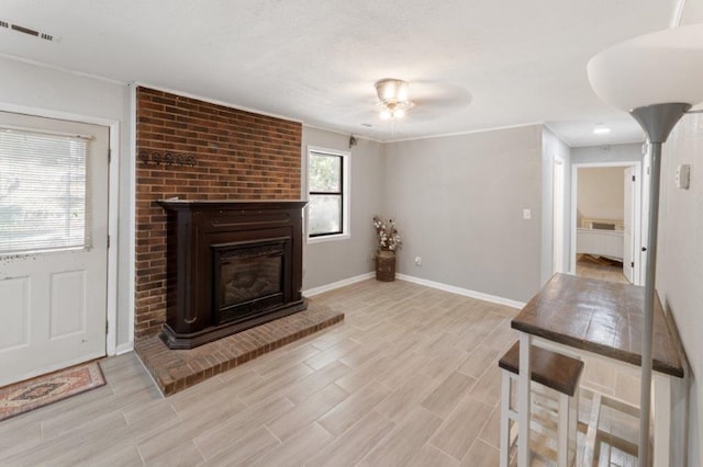 unfurnished living room with a brick fireplace and ceiling fan