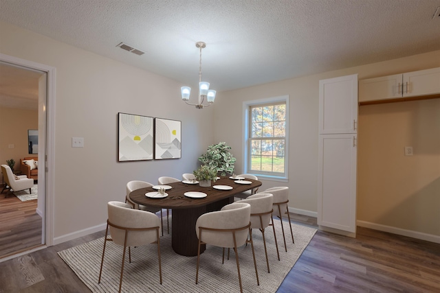 dining room with an inviting chandelier, hardwood / wood-style floors, and a textured ceiling