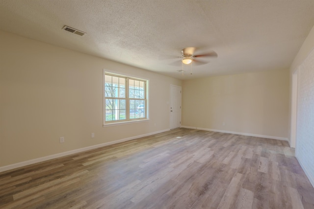 empty room featuring ceiling fan, a textured ceiling, and light wood-type flooring