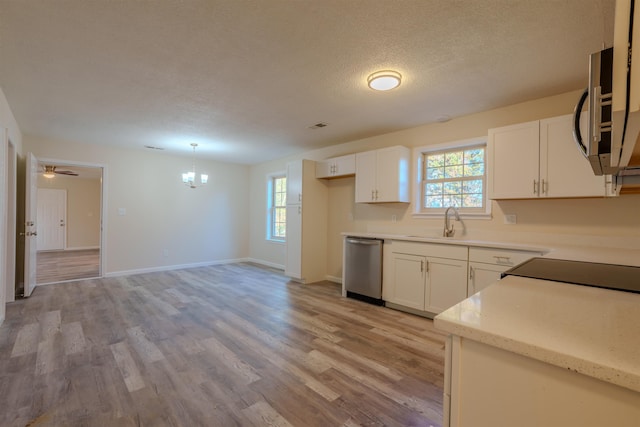 kitchen with sink, appliances with stainless steel finishes, hanging light fixtures, a healthy amount of sunlight, and white cabinets