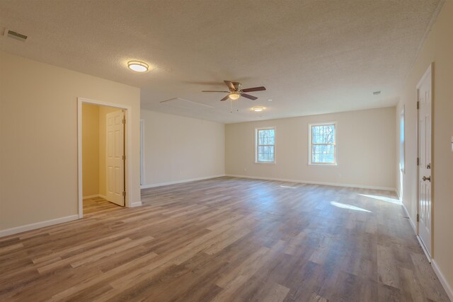 unfurnished room with ceiling fan, a textured ceiling, and light wood-type flooring