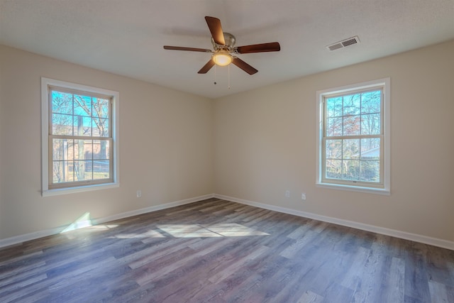 empty room with ceiling fan and dark hardwood / wood-style flooring