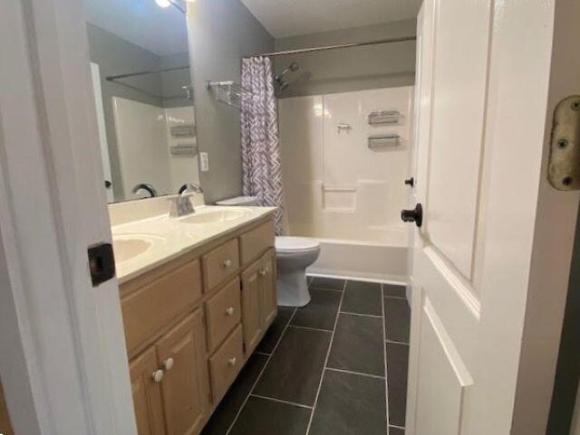  - bathroom featuring double vanity, toilet, tile patterned flooring, and shower / tub combo with curtain
