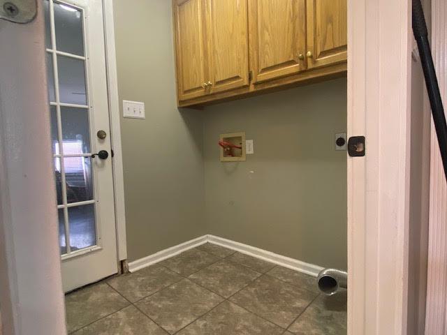  - laundry area with cabinet space, dark tile patterned floors, hookup for a washing machine, and baseboards