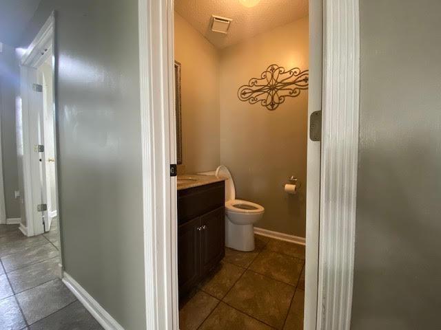  - bathroom featuring toilet, vanity, tile patterned flooring, and baseboards