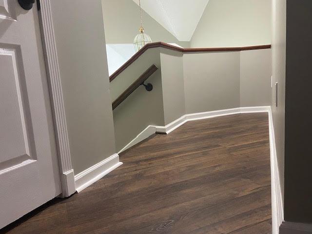  - stairway with wood finished floors, baseboards, and vaulted ceiling