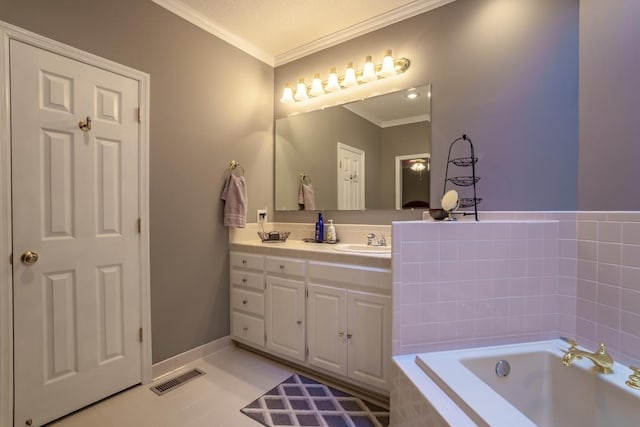 bathroom featuring tile patterned flooring, vanity, crown molding, and tiled tub