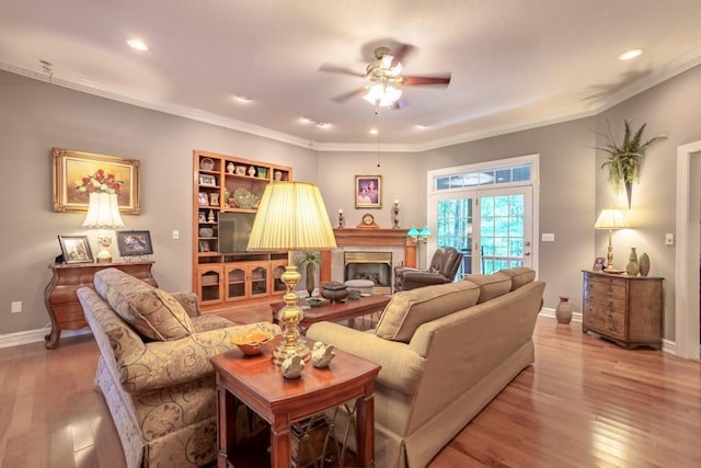 living room featuring wood-type flooring, ceiling fan, and crown molding