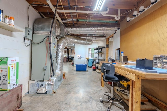 basement featuring a workshop area and heating unit