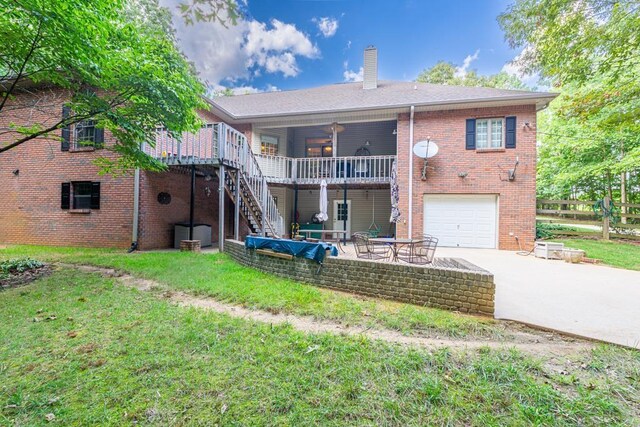 rear view of property with a patio, a garage, and a lawn