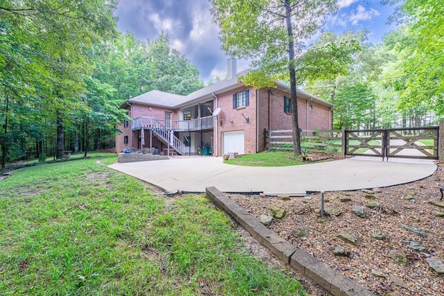 back of house featuring a lawn and a garage