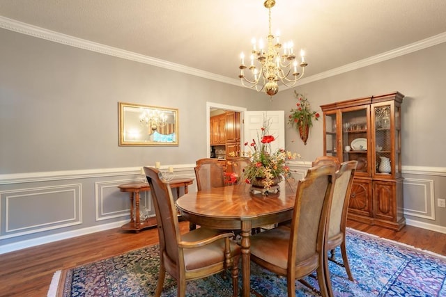 dining area featuring ornamental molding, dark wood-type flooring, and a notable chandelier