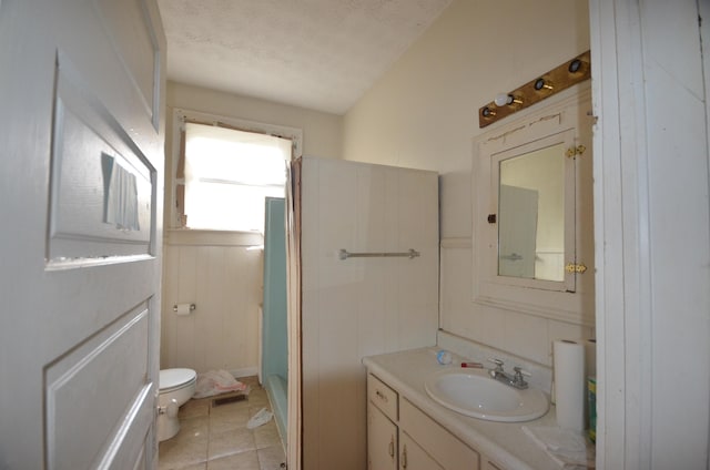 bathroom with tile patterned flooring, vanity, a textured ceiling, and toilet