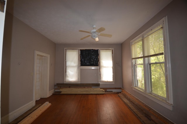 unfurnished room with ceiling fan, plenty of natural light, and wood-type flooring