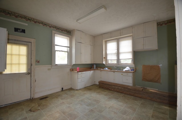 kitchen featuring sink, white cabinets, and a textured ceiling