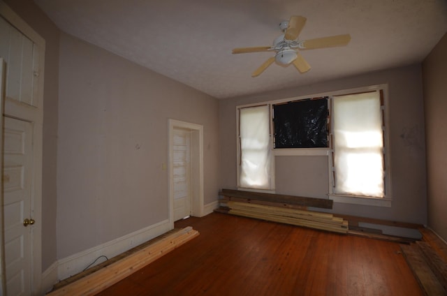 empty room with dark hardwood / wood-style floors and ceiling fan