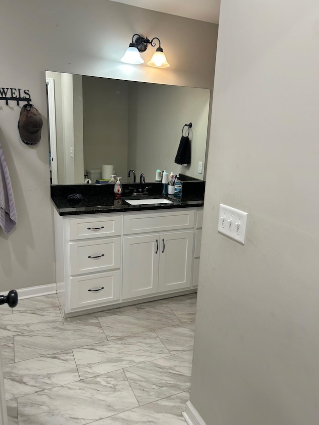 bathroom featuring marble finish floor, baseboards, and vanity