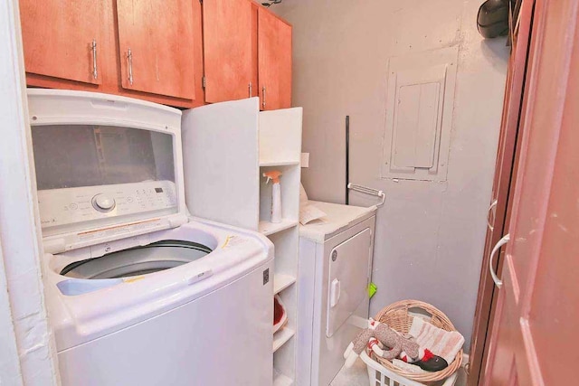 washroom with washer and clothes dryer, cabinets, and electric panel